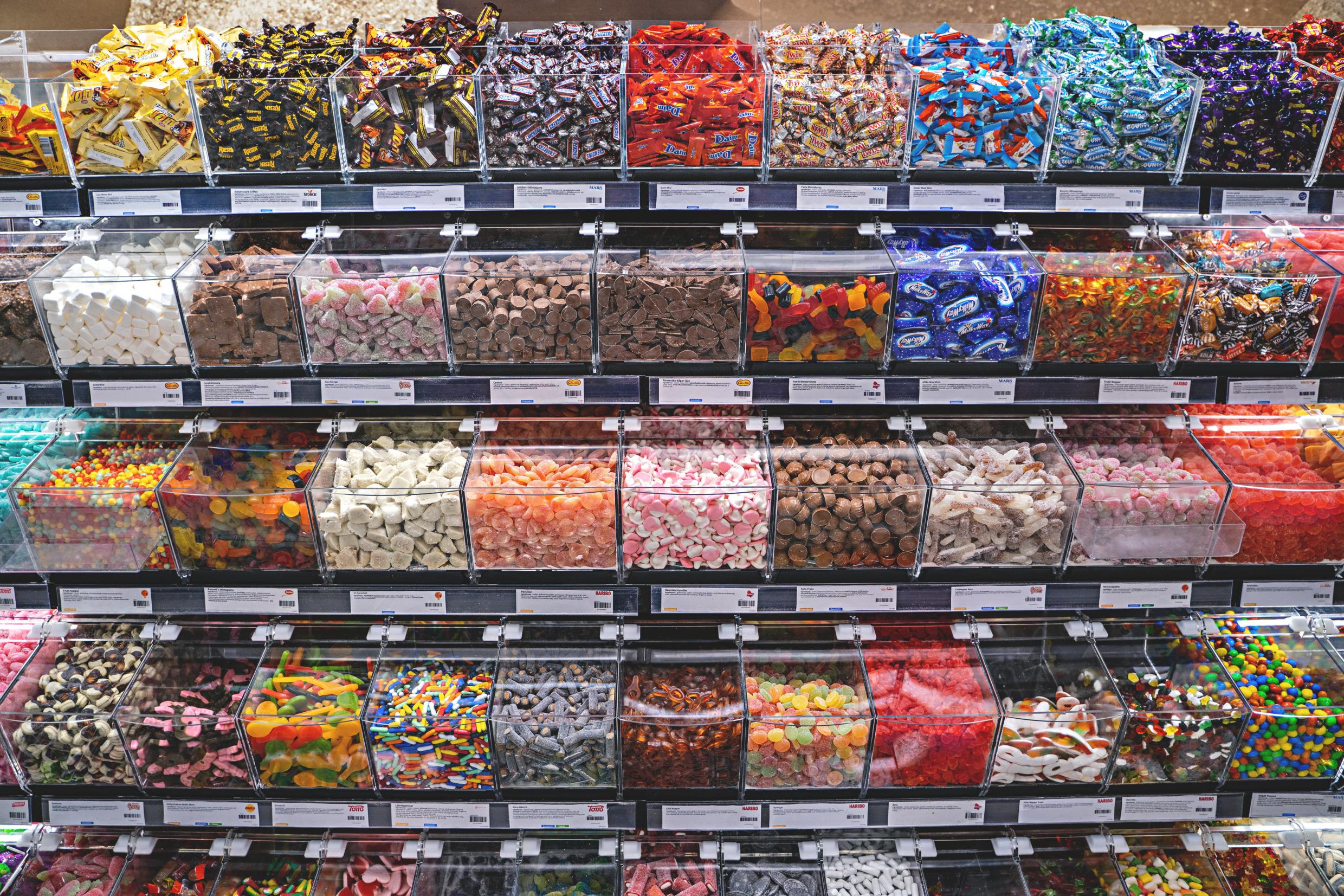 Rows and rows of containers with pieces of candy for sale in a store.