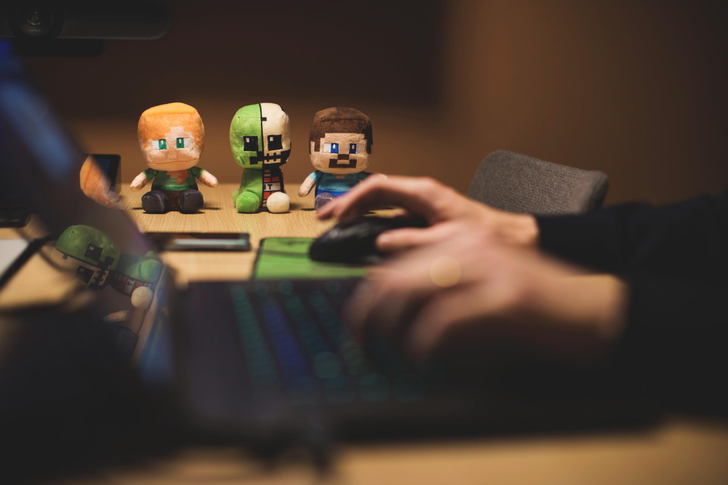 A desk with figures on it. Hands can be seen typing on a keyboard.