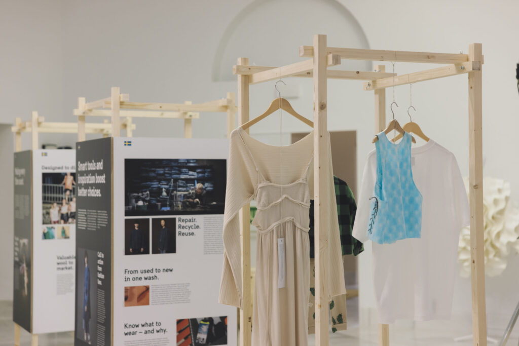 Garments hanging on a wooden exhibition module.