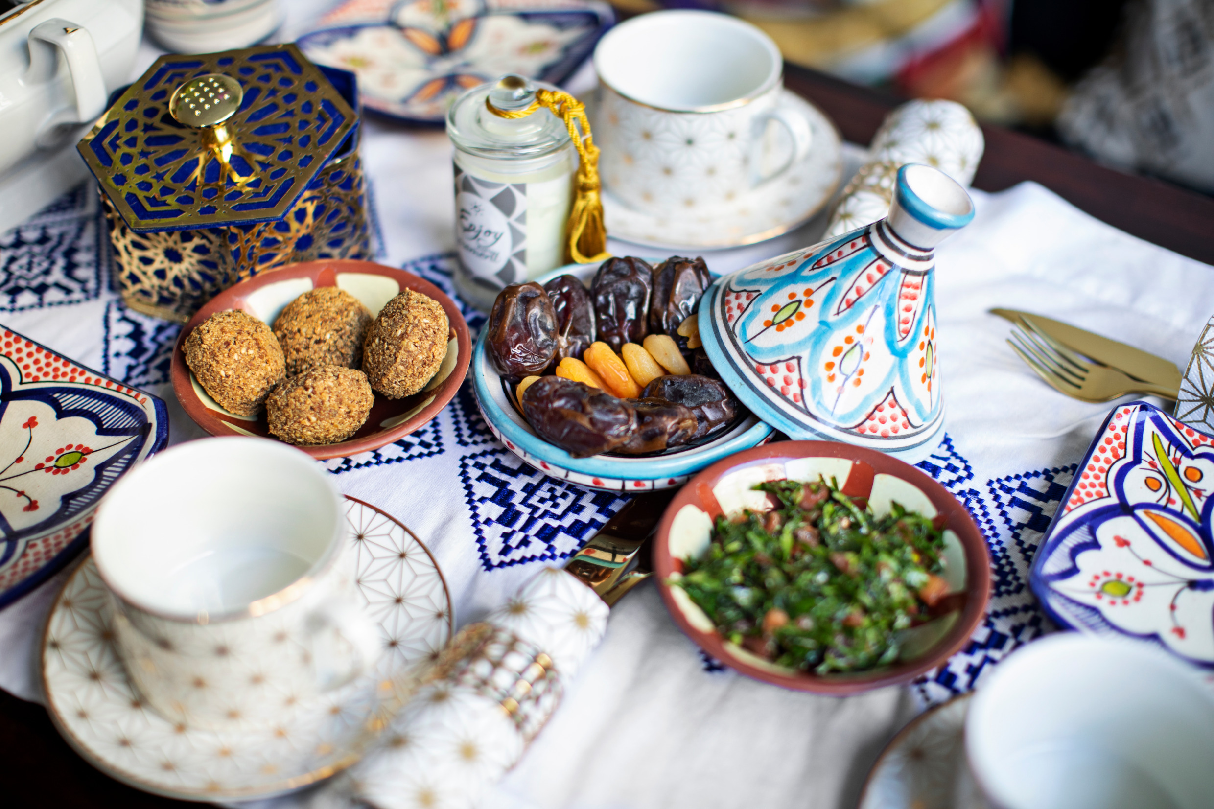 A festive table with falafel, dates, herbs.