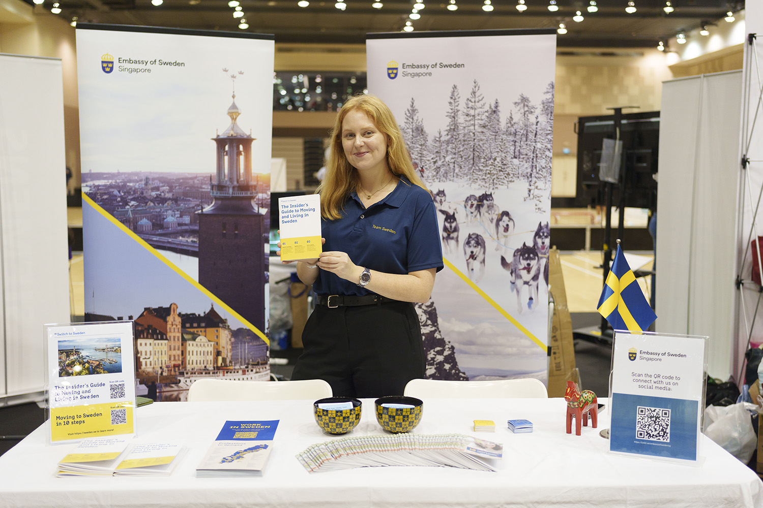 A woman working at the embassy at table with info about careers in Sweden.
