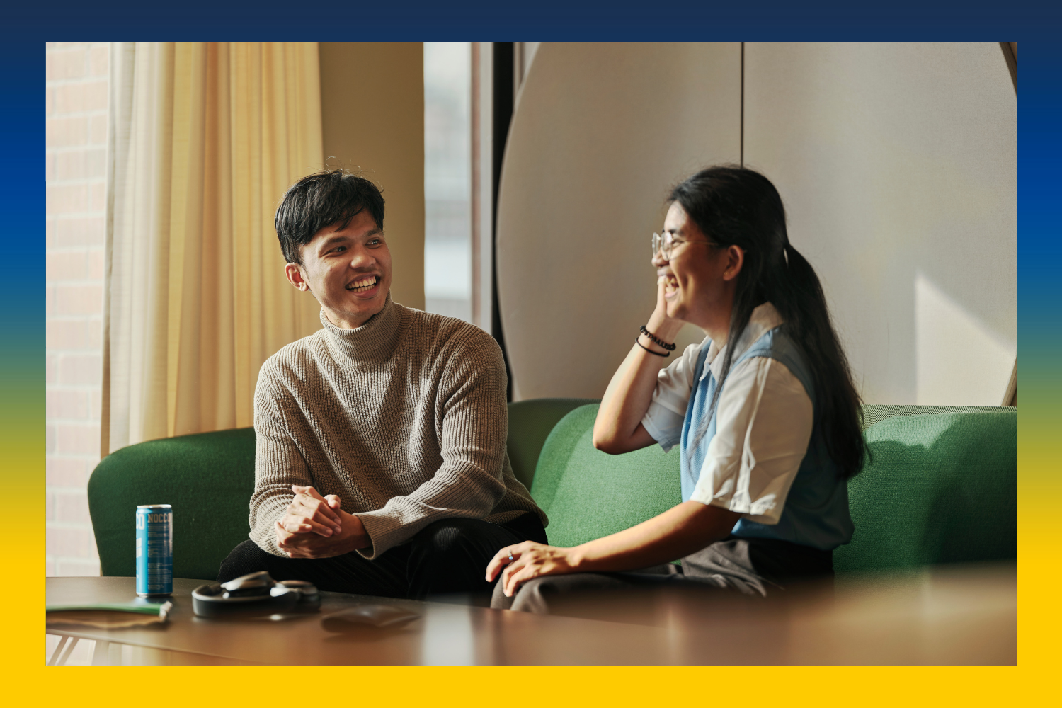 Two students having a conversation at a coffee table.